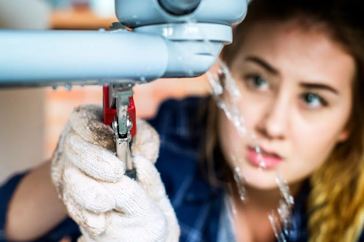 Plumbing Apprentice Working On Leak Underneath Sink